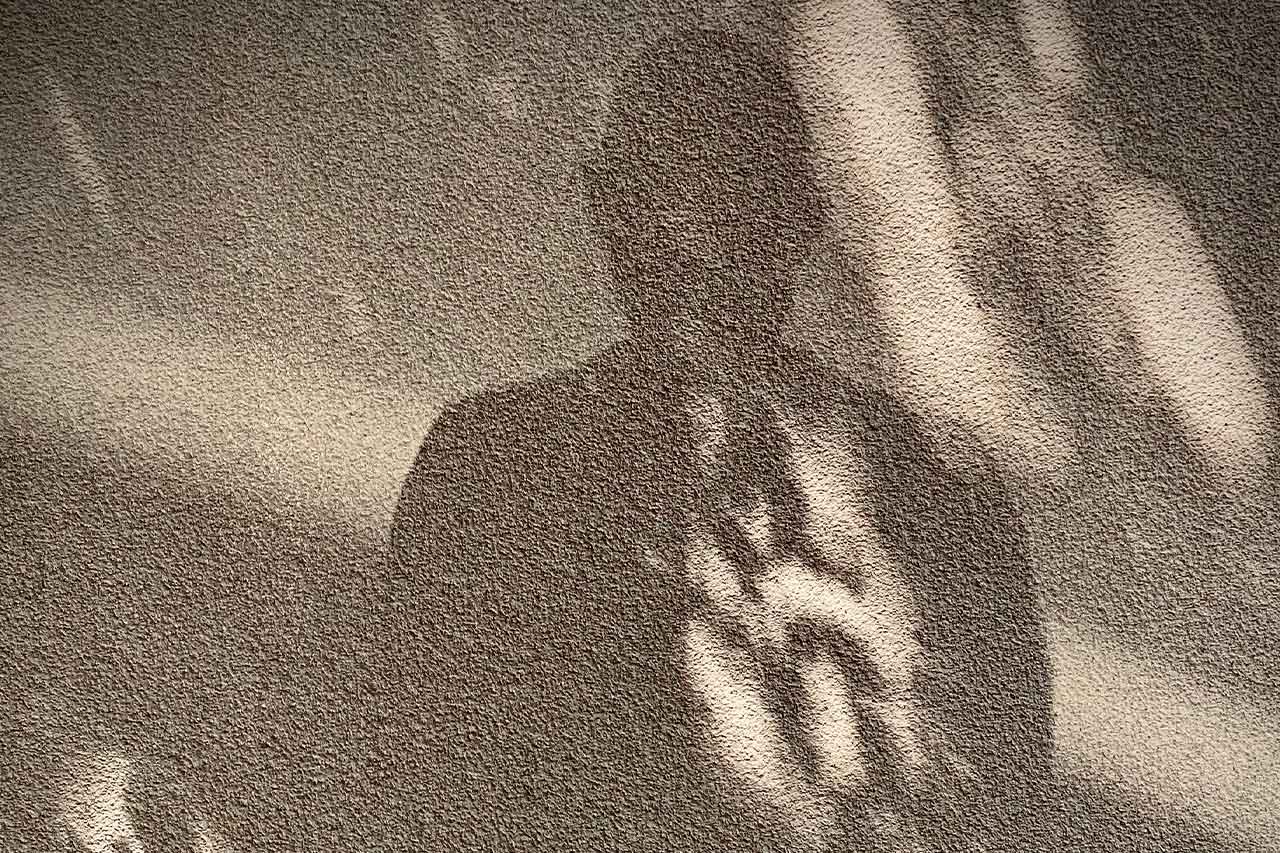 Schattenriss einer Person auf strukturierter Wand