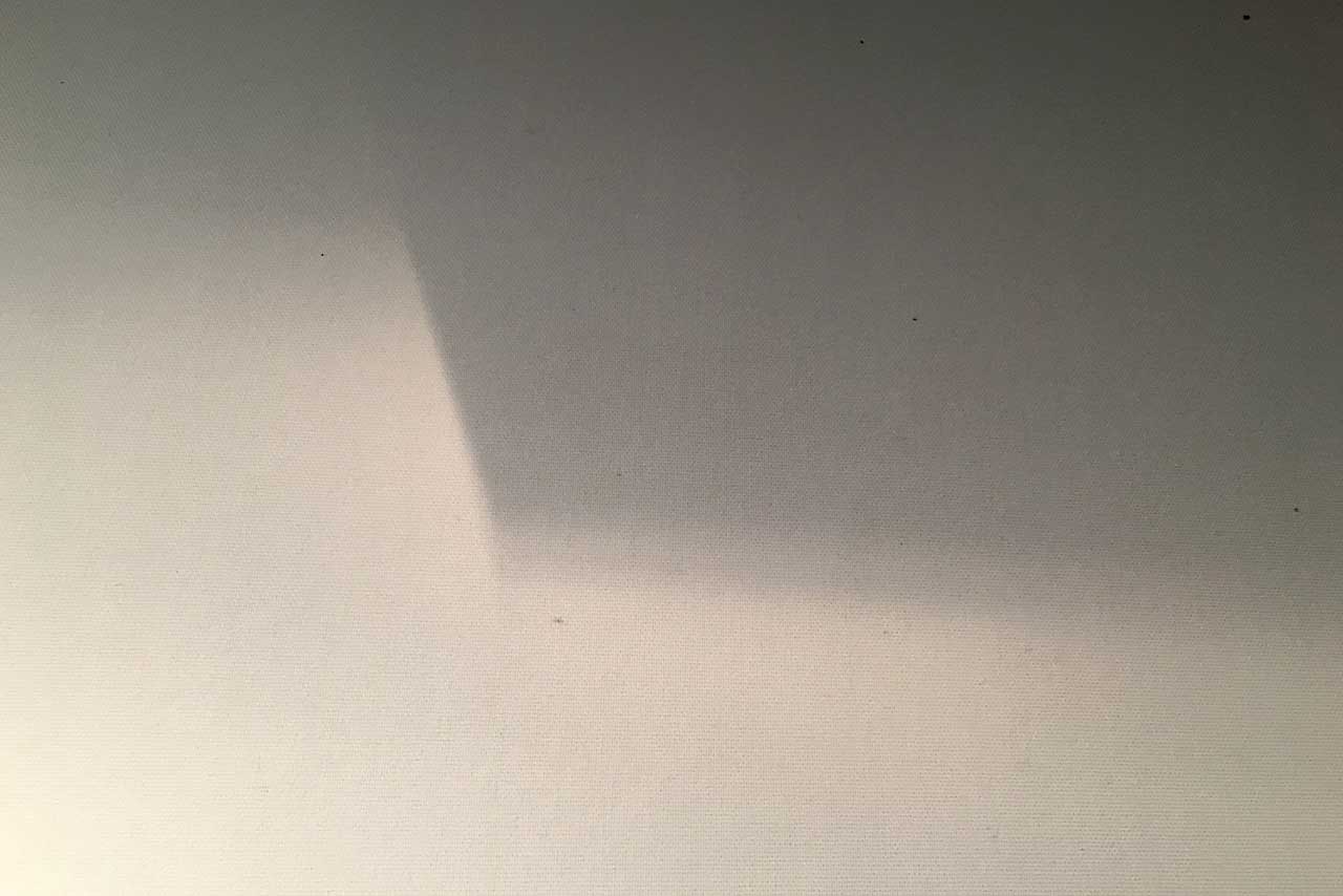 sanfte schattenspiele auf einer wand, licht und dunkel verschieben sich, offen und still, rhythmus in bewegung