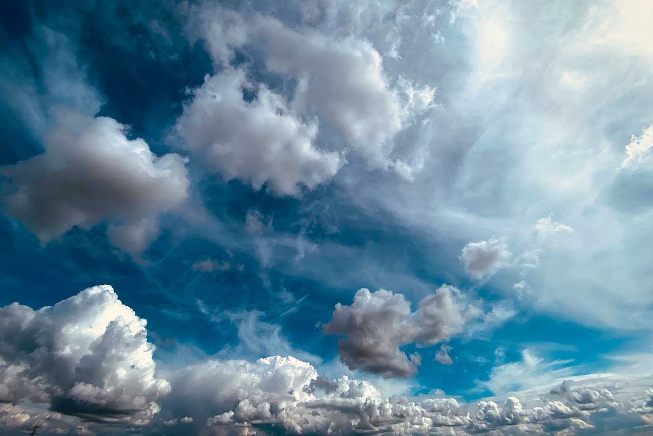 wolken und nebel vor blauem himmel, fließend und lichtdurchlässig, wie ein hauchgewebe in bewegung